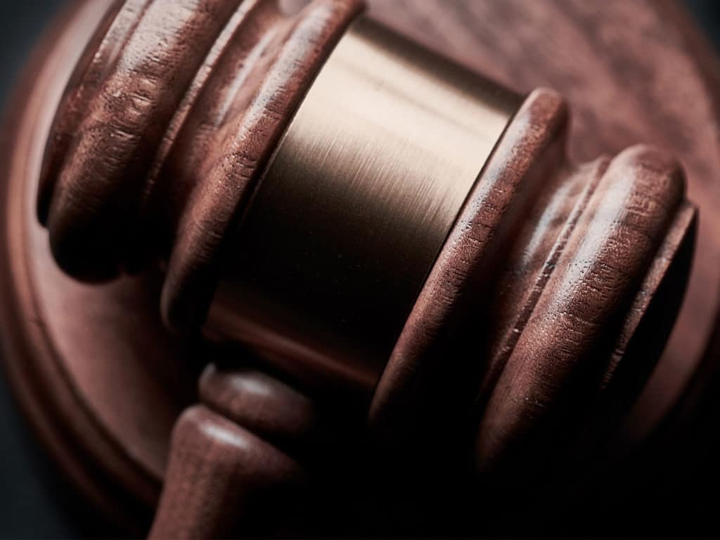 Judge's gavel resting on wooden block.