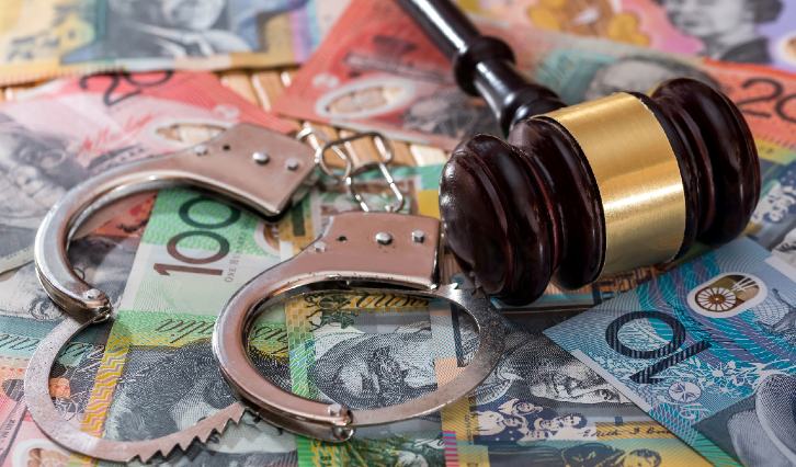 Australian money with handcuffs and gavil representing proceeds of crime